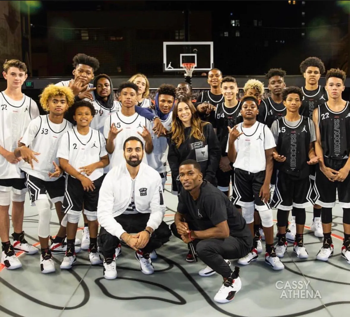 Tyler Bell crouched with the Jordan Brand youth team on the court at Jumpman LA